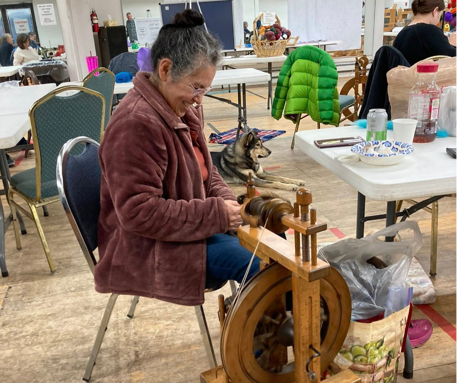Guild member on a spinning wheel during Open Studio